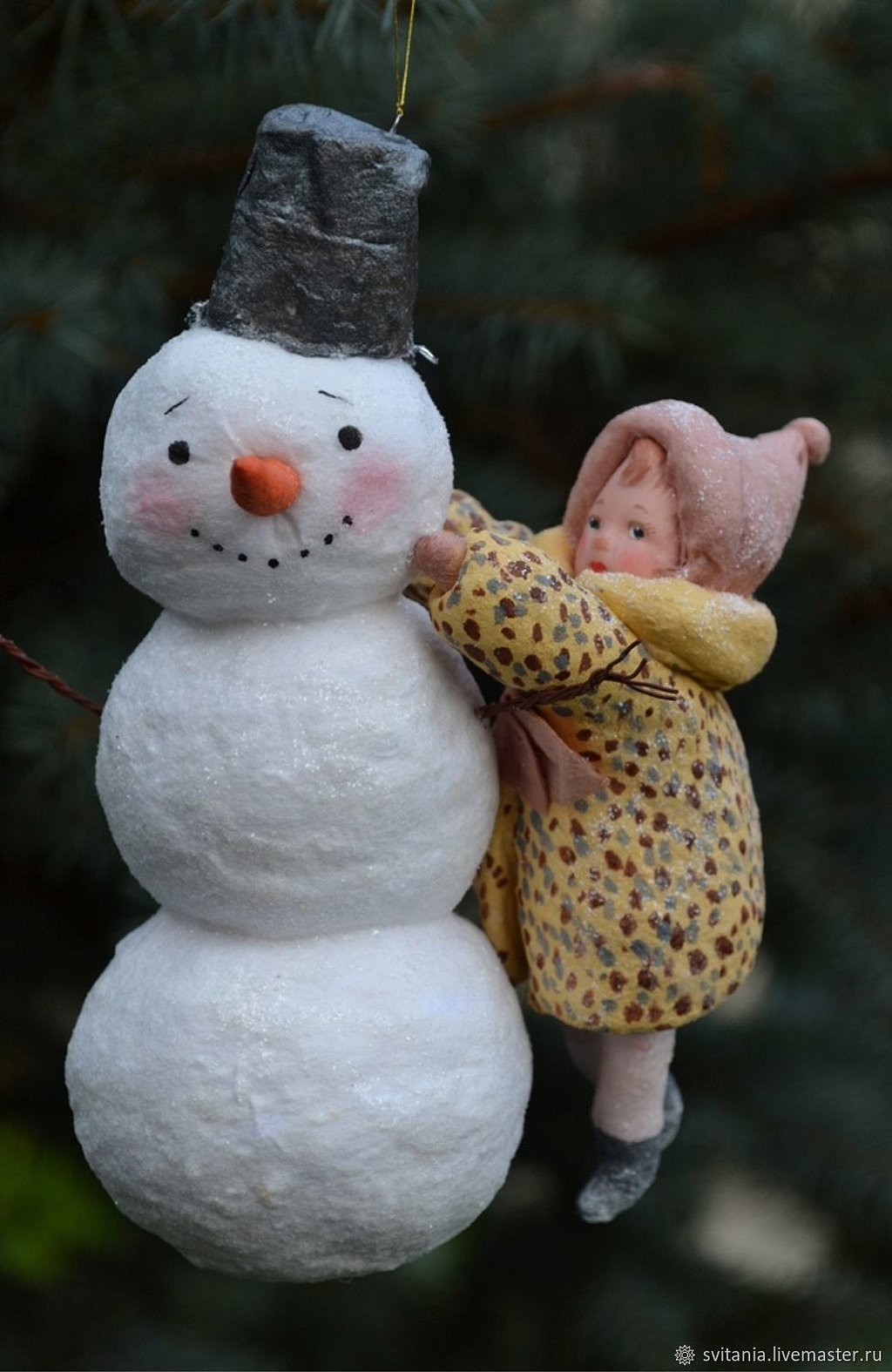 Snømann og jente ved juletreet
