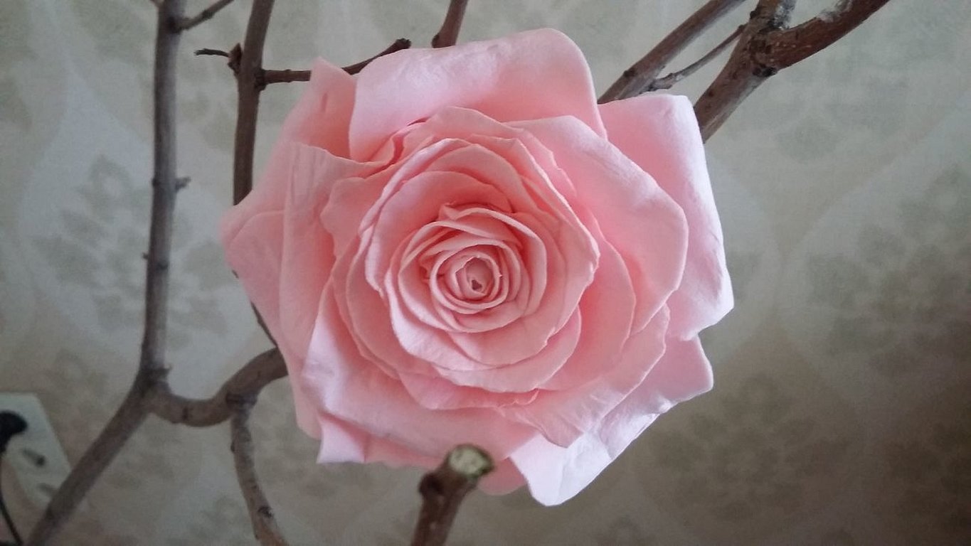 Rosa kunstig rose på en gren