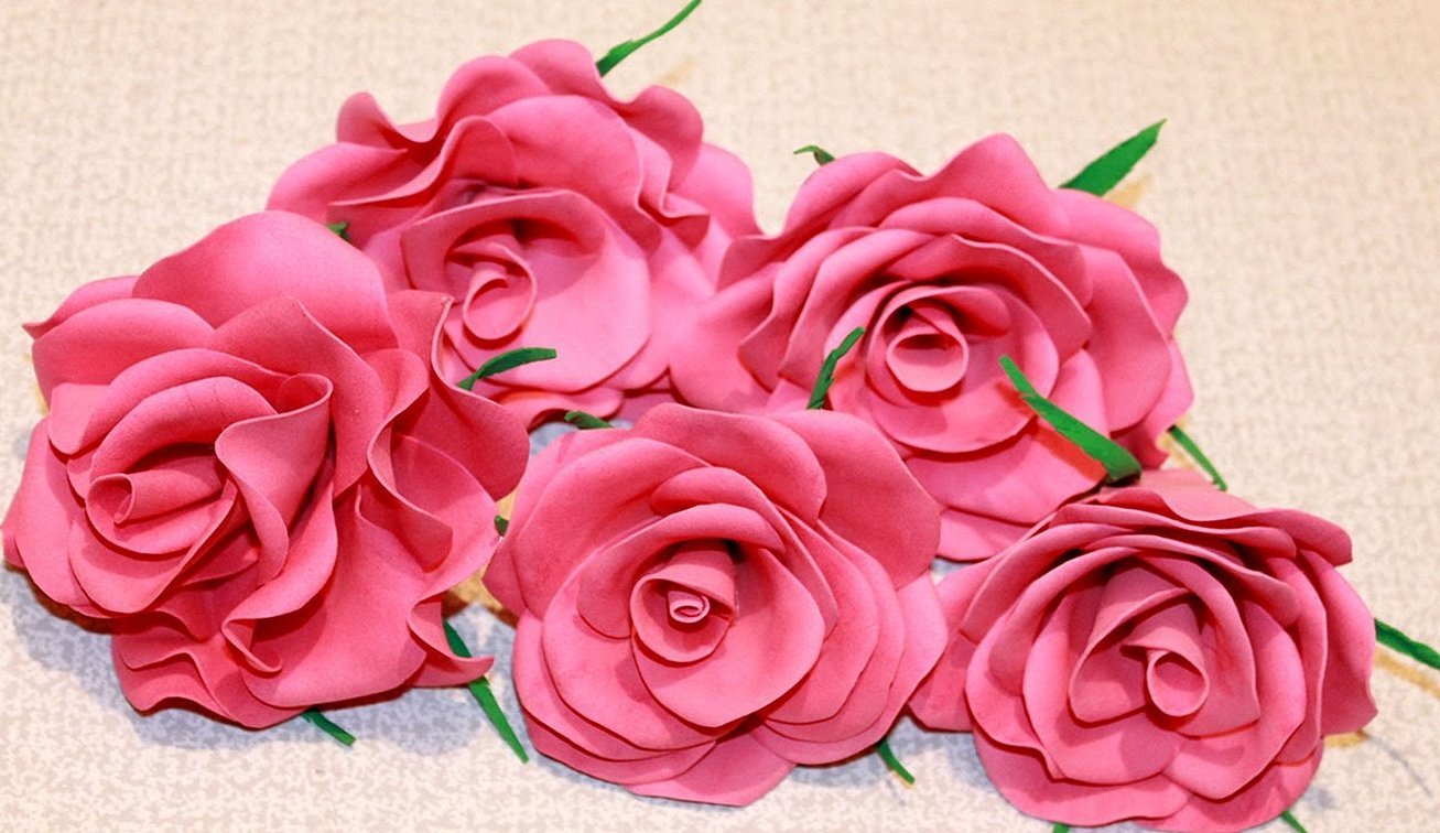 Rosa blomster med små grønne blader